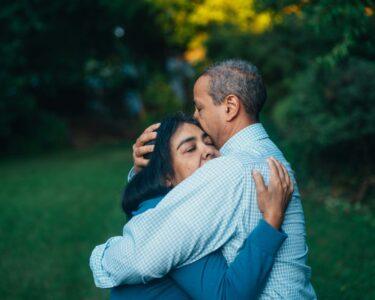 man hugging woman near trees
