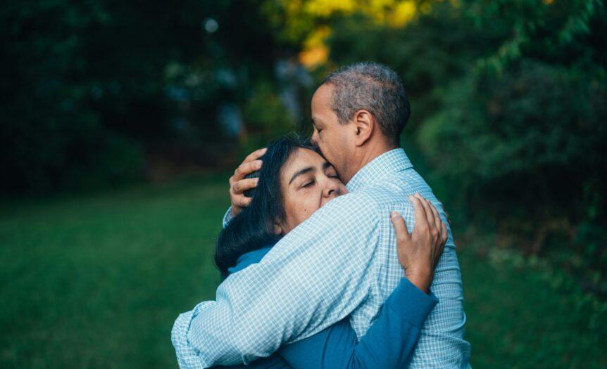 man hugging woman near trees