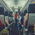 flight attendant standing between passenger seat