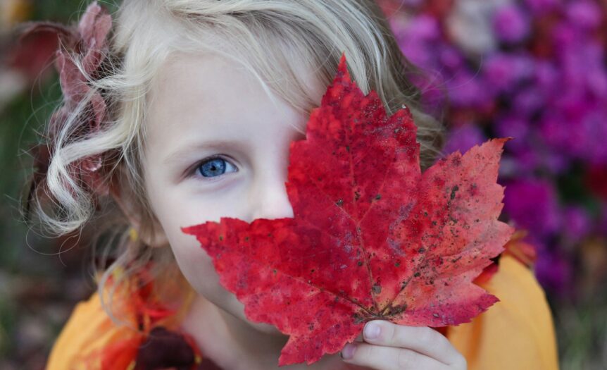 girl holding red maple leaf