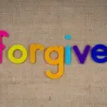 Vibrant felt letters spelling 'forgive' on a burlap background.