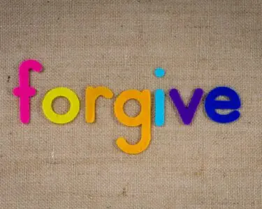 Vibrant felt letters spelling 'forgive' on a burlap background.