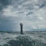 photo of person reach out above the water