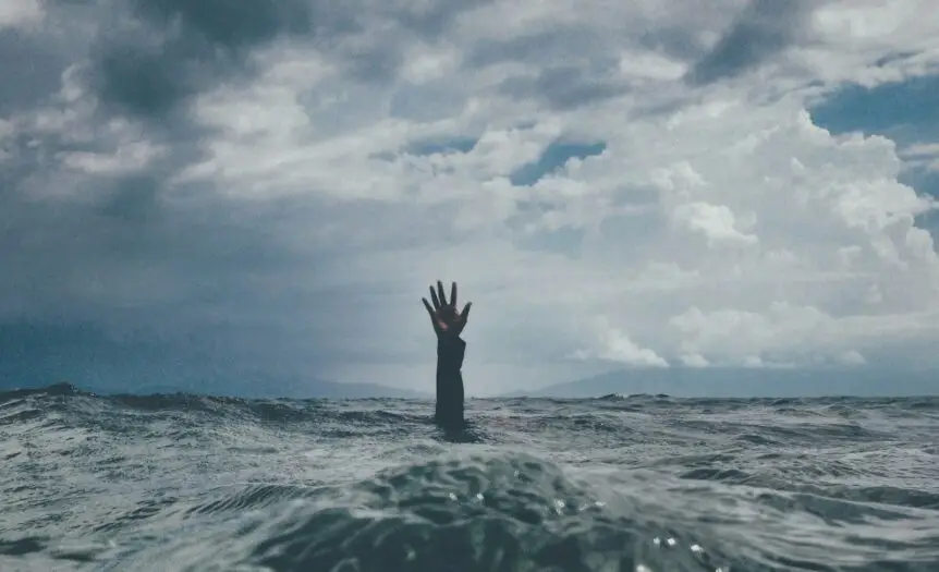 photo of person reach out above the water