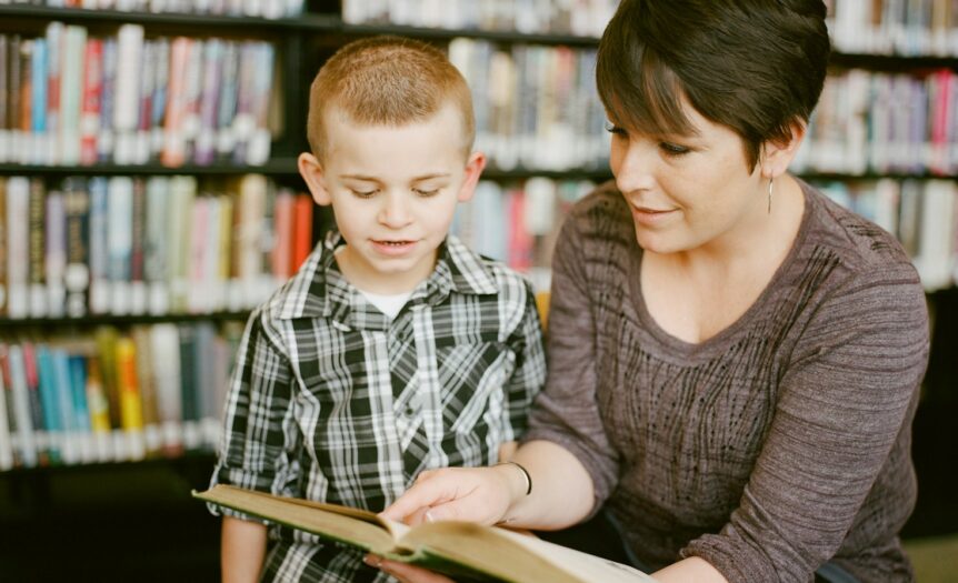 boy in gray sweater beside boy in gray and white plaid dress shirt