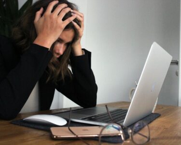 a woman sitting in front of a laptop computer