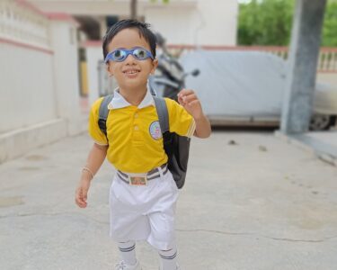 a boy wearing a backpack and sunglasses