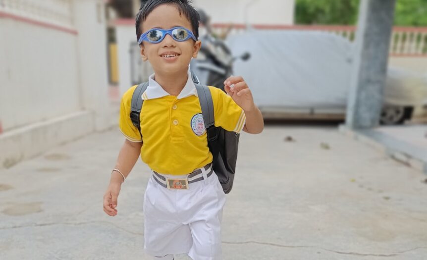 a boy wearing a backpack and sunglasses