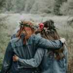 woman in blue denim jacket with red rose on ear