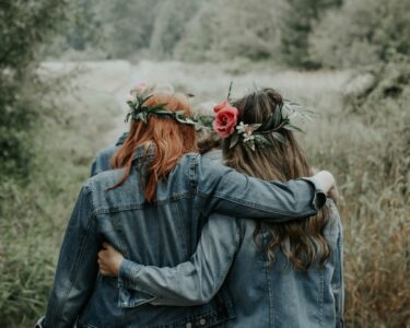 woman in blue denim jacket with red rose on ear