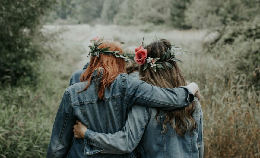 woman in blue denim jacket with red rose on ear
