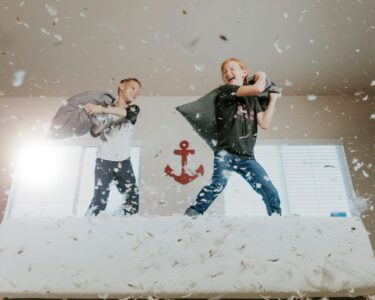 two toddler pillow fighting