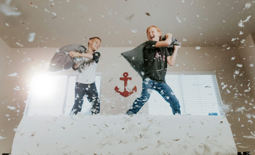 two toddler pillow fighting