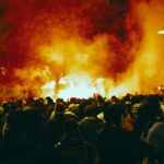 a large group of people standing around a fire