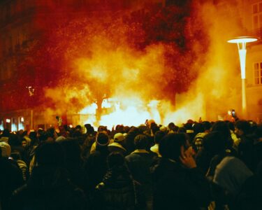 a large group of people standing around a fire