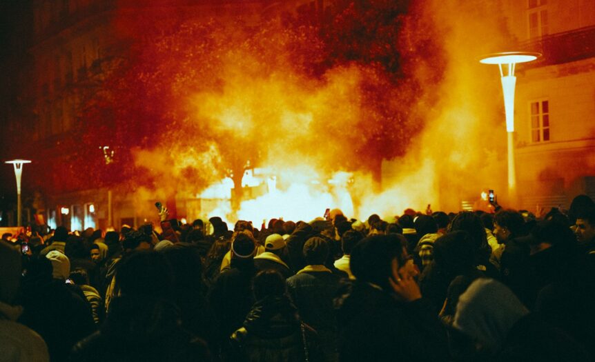 a large group of people standing around a fire