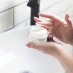 person holding white and black plastic bottle