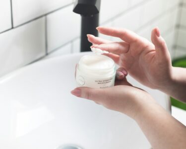 person holding white and black plastic bottle