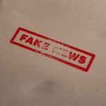 a stamp that reads fake news on a piece of paper