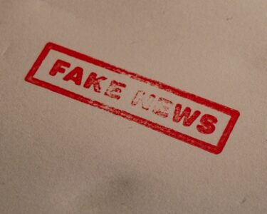 a stamp that reads fake news on a piece of paper