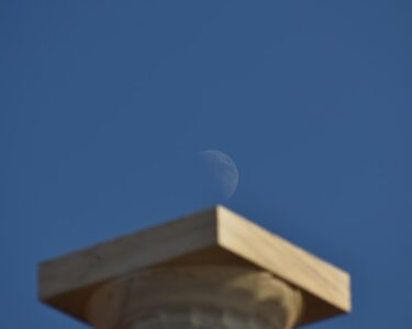 a stone building with a moon in the sky