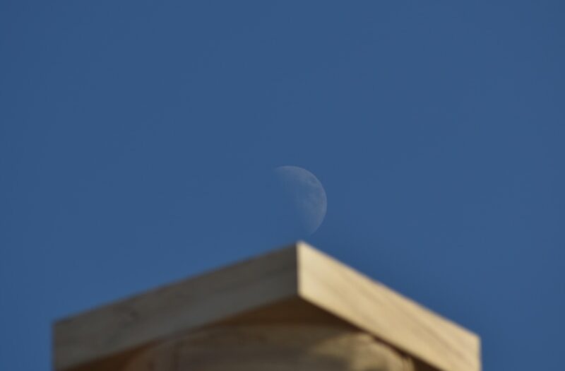 a stone building with a moon in the sky