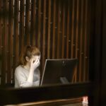 Burnout a woman sitting in front of a laptop computer