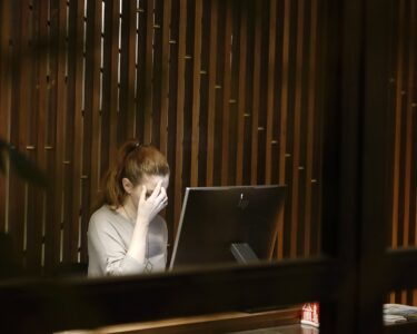 Burnout a woman sitting in front of a laptop computer
