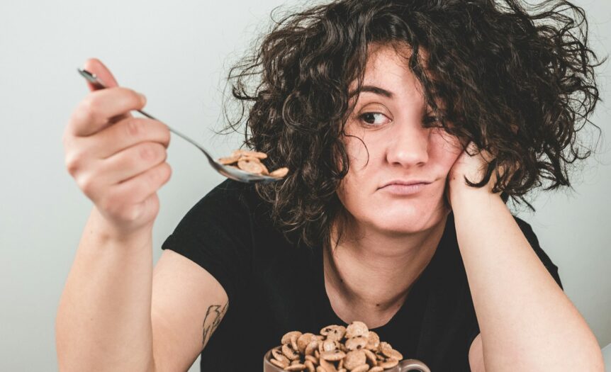 Διατροφή woman with messy hair wearing black crew-neck t-shirt holding spoon with cereals on top