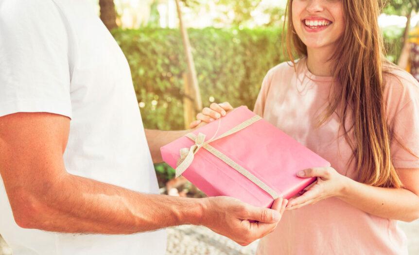 smiling woman giving valentine gift her boyfriend