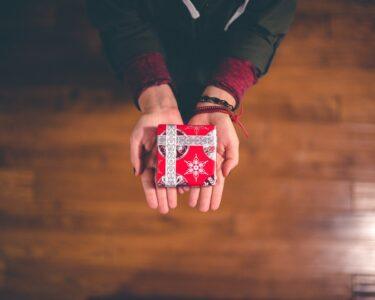 person holding red and white box