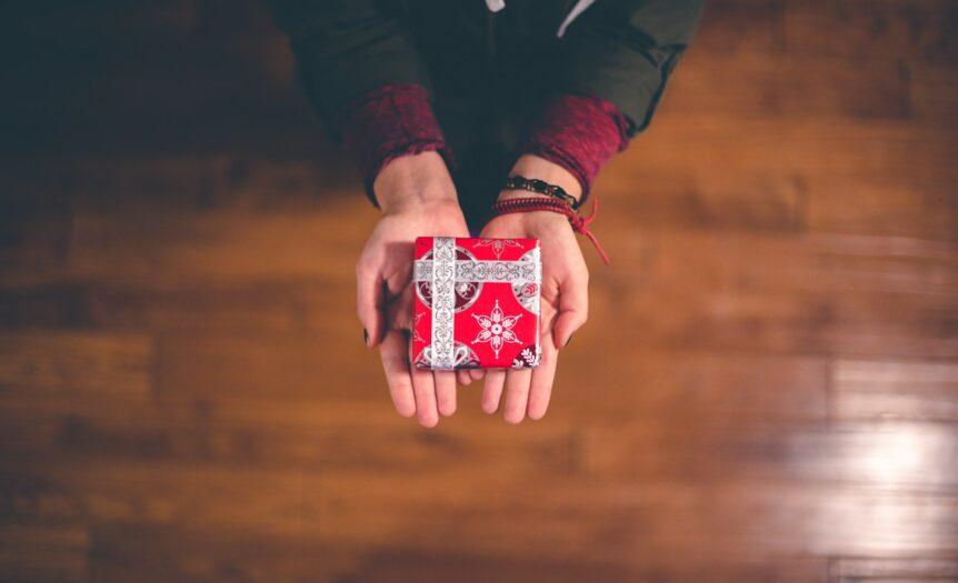 person holding red and white box