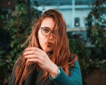 woman wearing teal sweater and eyeglasses