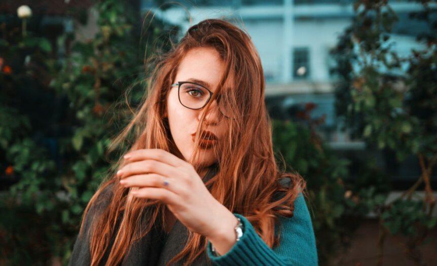 woman wearing teal sweater and eyeglasses