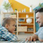 Father and son looking at each other on floor