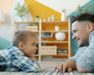 Father and son looking at each other on floor