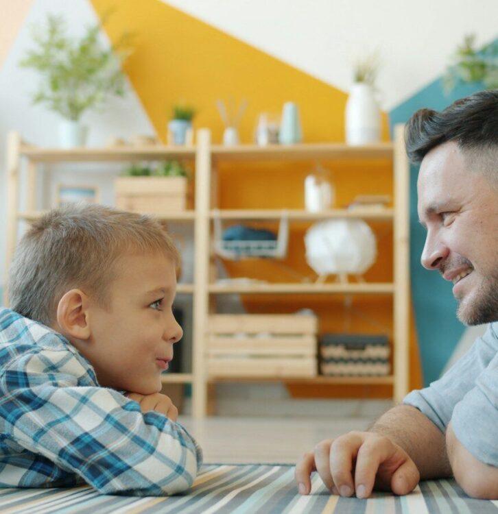 Father and son looking at each other on floor