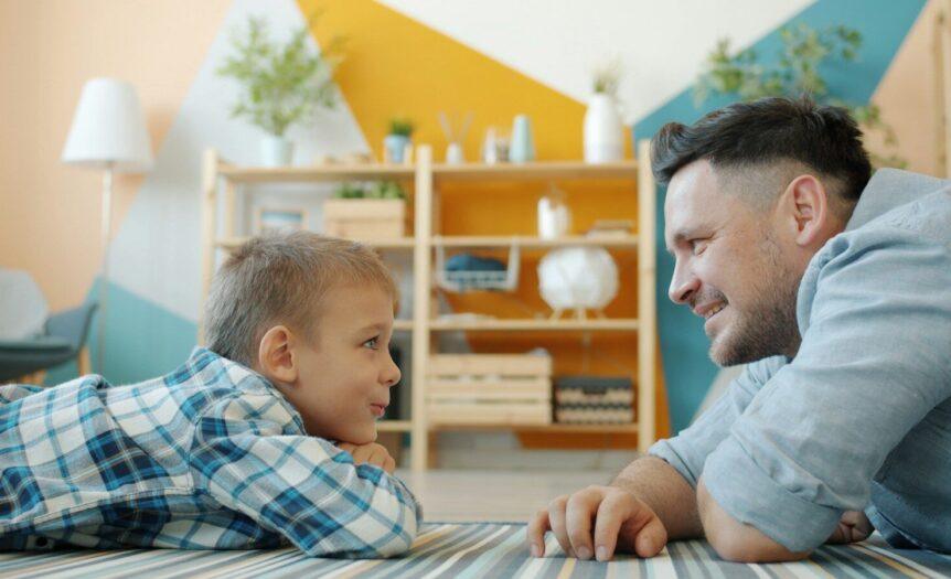 Father and son looking at each other on floor