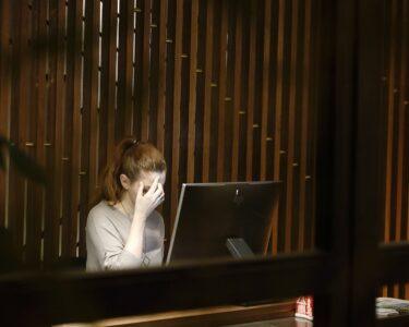 a woman sitting in front of a laptop computer