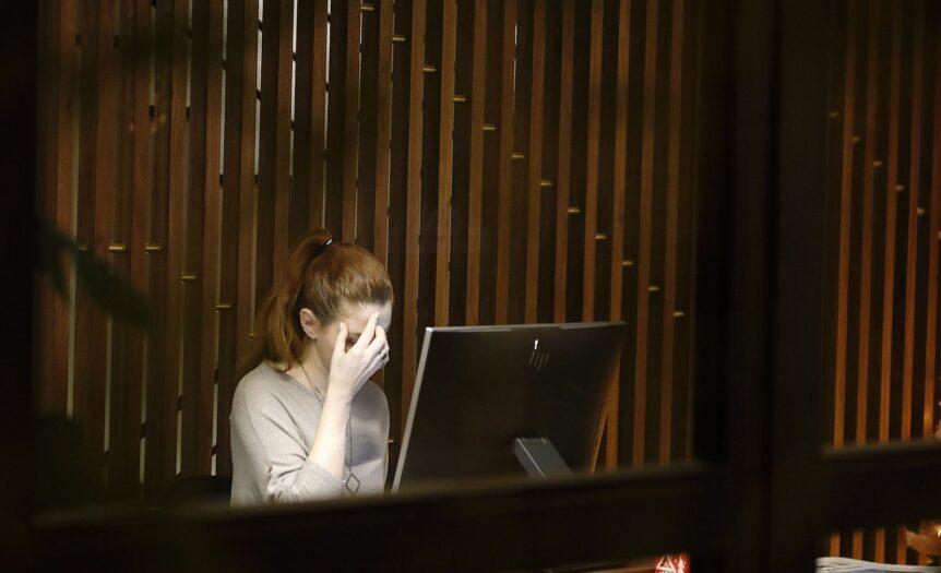 a woman sitting in front of a laptop computer