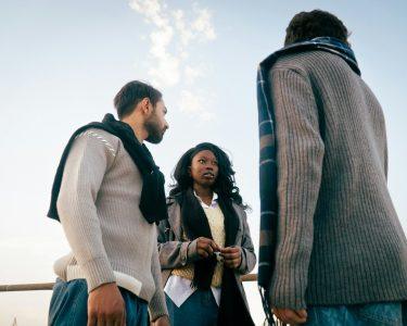 Τρεις άνθρωποι συζητούν σε εξωτερικό χώρο – ανθρώπινες σχέσεις και ψυχολογική ευημερία