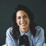 smiling woman in white and black checkered dress shirt