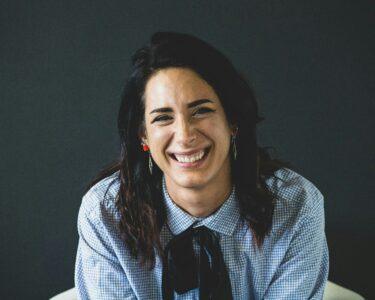 smiling woman in white and black checkered dress shirt