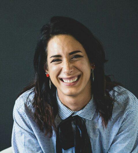 smiling woman in white and black checkered dress shirt
