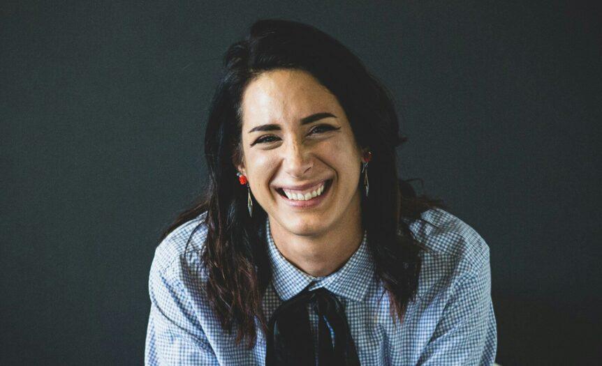 smiling woman in white and black checkered dress shirt