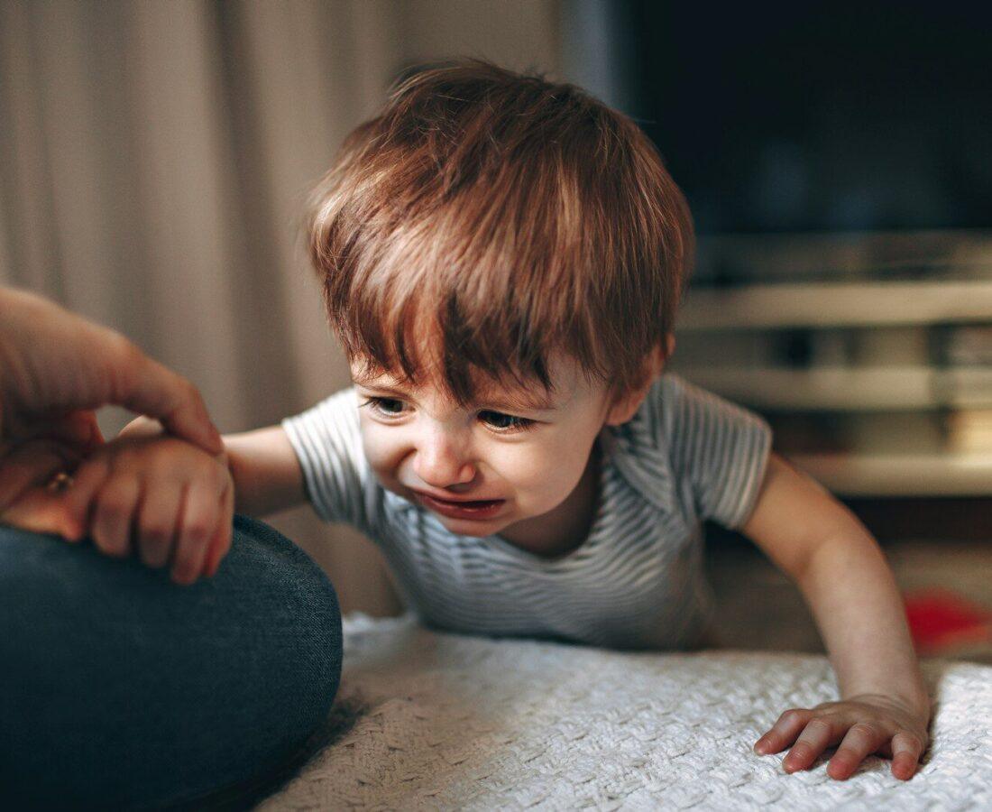 boy in gray and white striped shirt sitting on floor