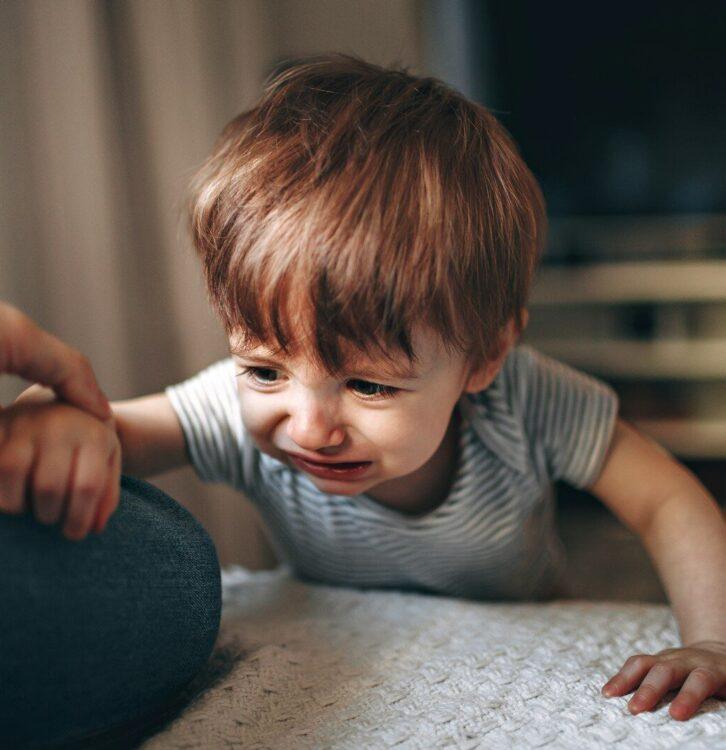 boy in gray and white striped shirt sitting on floor