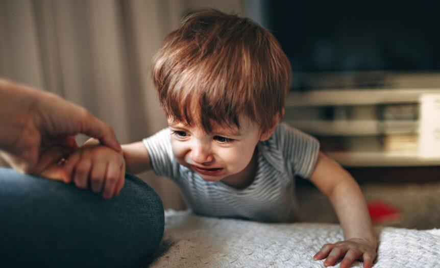 boy in gray and white striped shirt sitting on floor